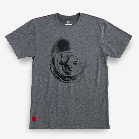 A heather gray crewneck t-shirt featuring a black graphic print of a skull inside an astronaut helmet on the front. A small red square logo is visible on the bottom left hem.