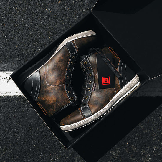Indie Ridge Comanche waterproof motorcycle boots in a black branded box, showcasing the brown distressed leather finish, white outsole, and included packaging.