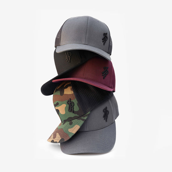 Stack of baseball caps with different designs on a white background