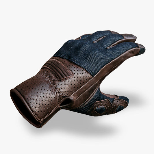 Brown perforated leather and blue denim glove on a white background